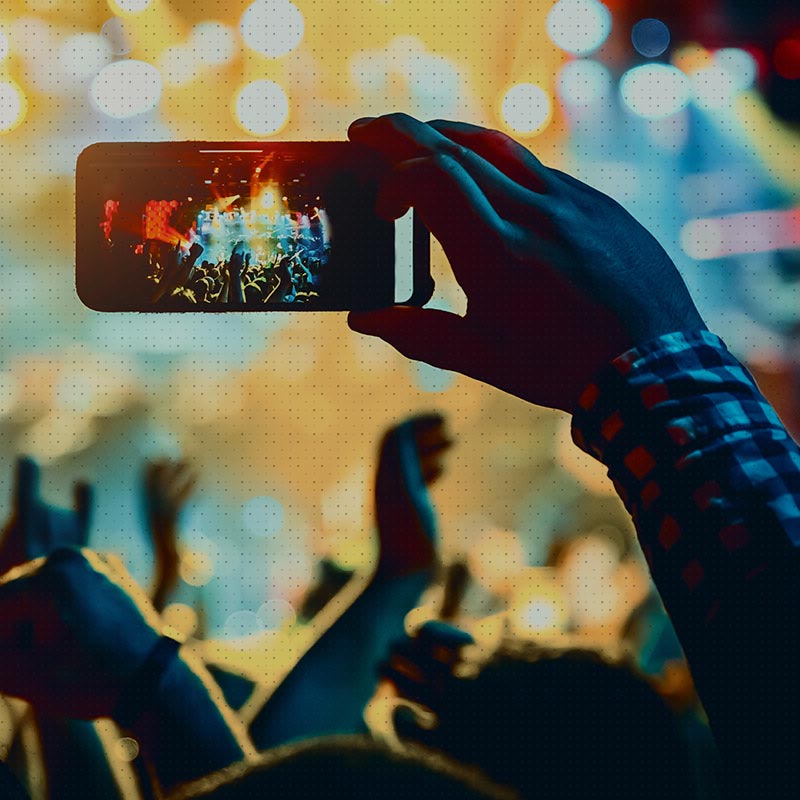 Photo d'une personne utilisant son smartphone pendant un concert